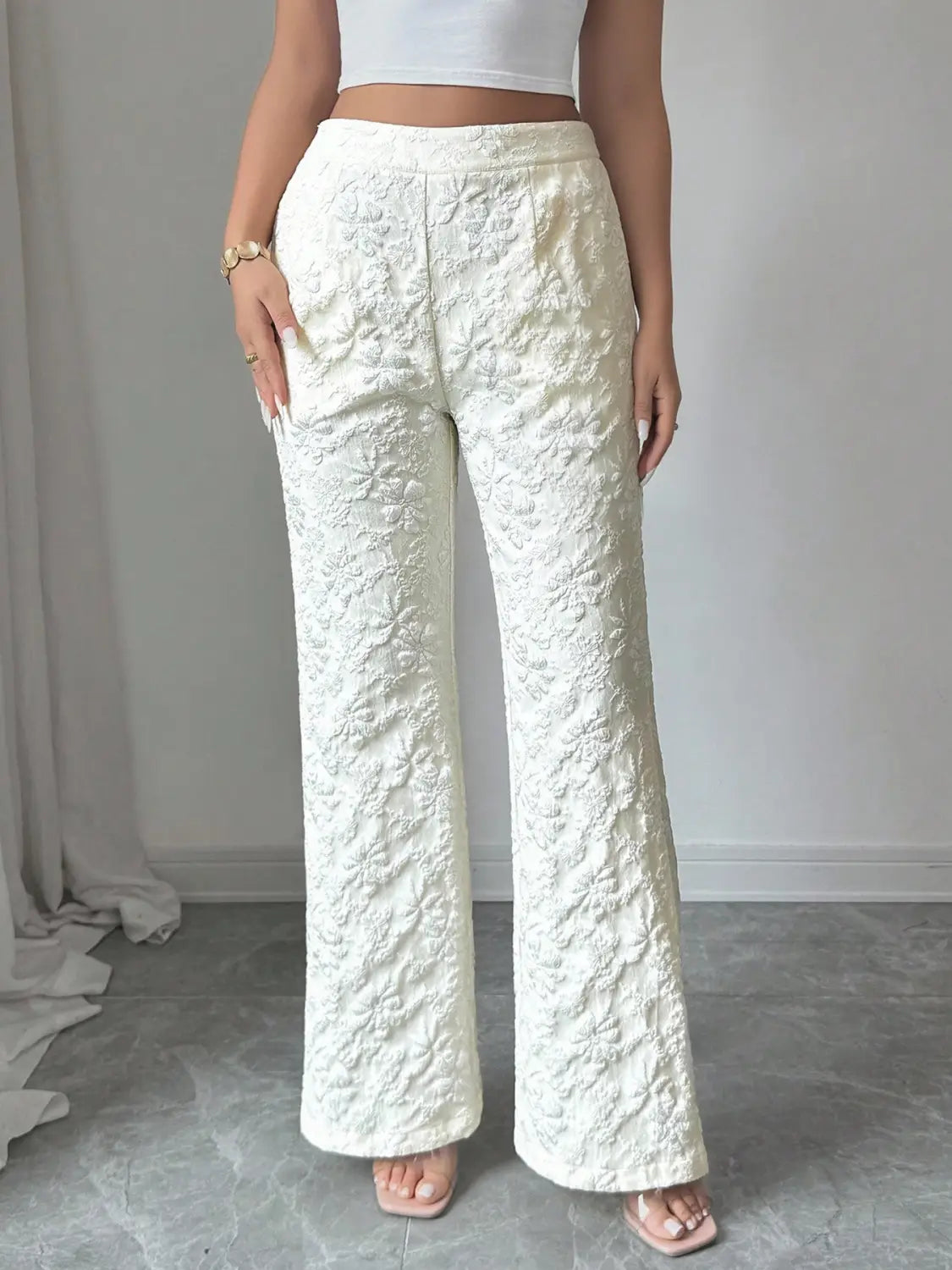 Weiße Spitzenhose mit hoher Taille und weitem Bein mit einem Spitzenmuster, mit hoher Taille und ausgestellten Beinen.