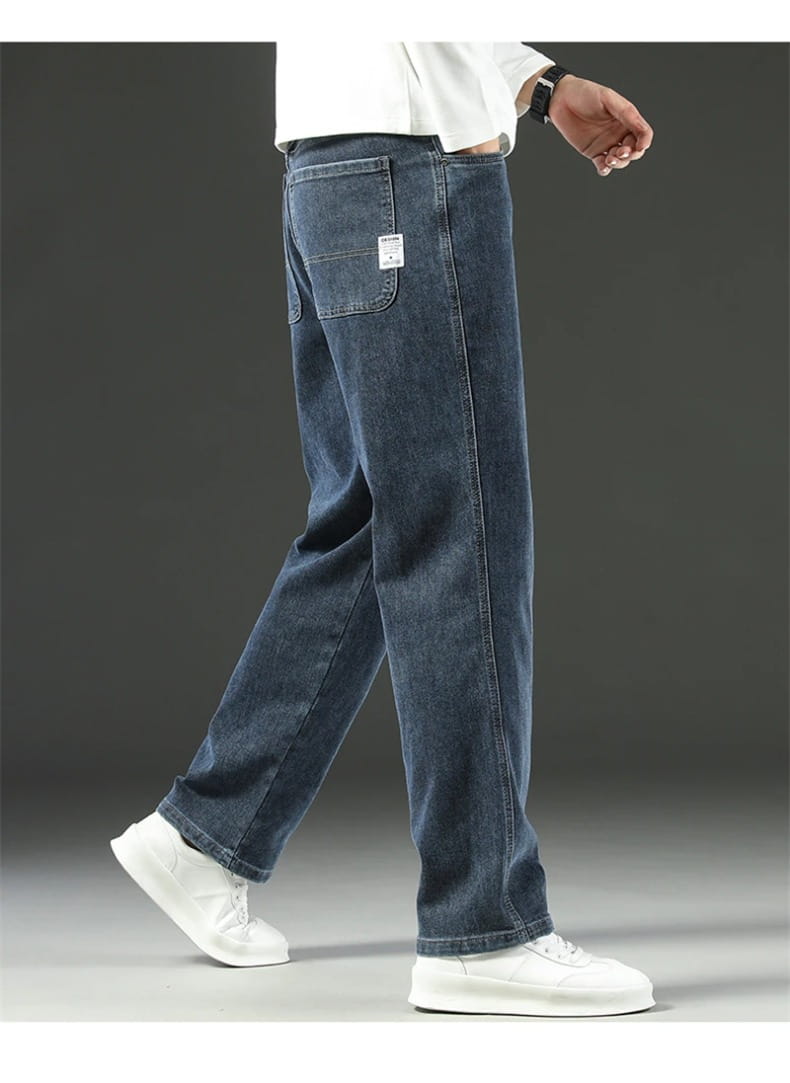 Dark blue denim men’s loose straight business casual jeans with a relaxed fit and subtle fading shown from the back featuring a small white label on the back pocket.