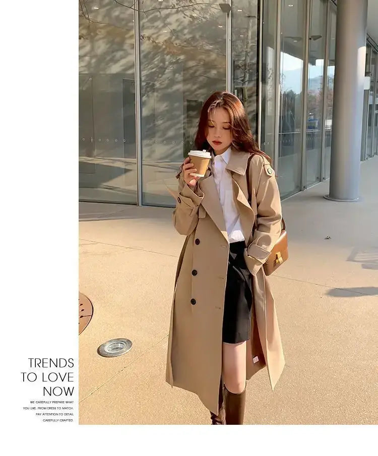 Beige women double-breasted trench coat with black buttons in a casual windbreaker style.