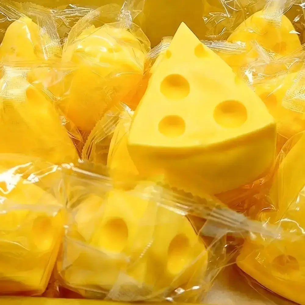 Boule anti-stress souple de forme de fromage jaune, avec des perforations caractéristiques, en mousse souple enveloppée dans un film plastique transparent pour une utilisation en tant que jouet sensoriel