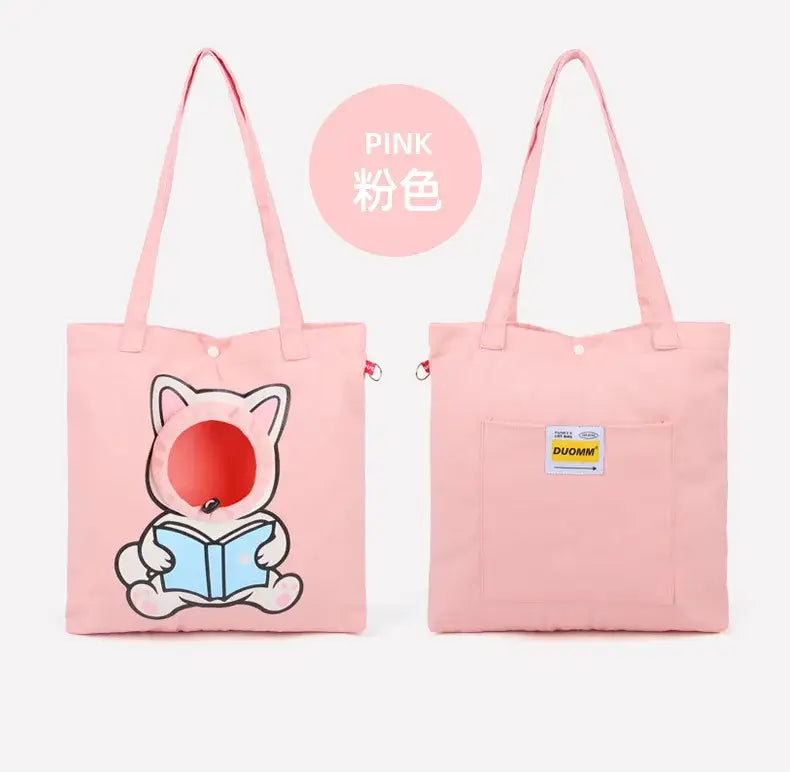 Sac tote en toile rose avec un chat en dessin animé aux joues rouges lisant un livre et la marque « duomm » sur la poche avant, conçu pour les voyages en extérieur et l’usage pour chiot et chat domestiques