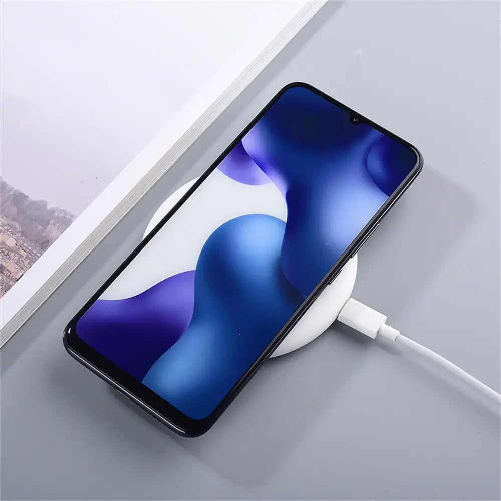 Schwarzes Smartphone mit schlankem, modernem Design, das auf einer weißen kabellosen Ladestation mit 20-W-Schnellladung für Xiaomi Pro Max liegt