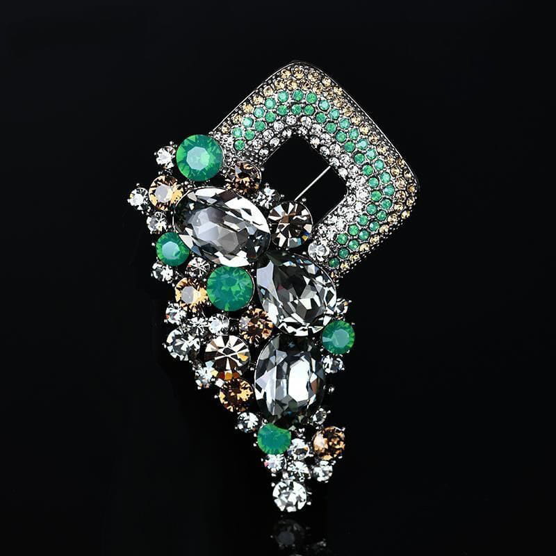A sparkling green and clear rhinestone crystal flower brooch pin for women with a geometric frame design.