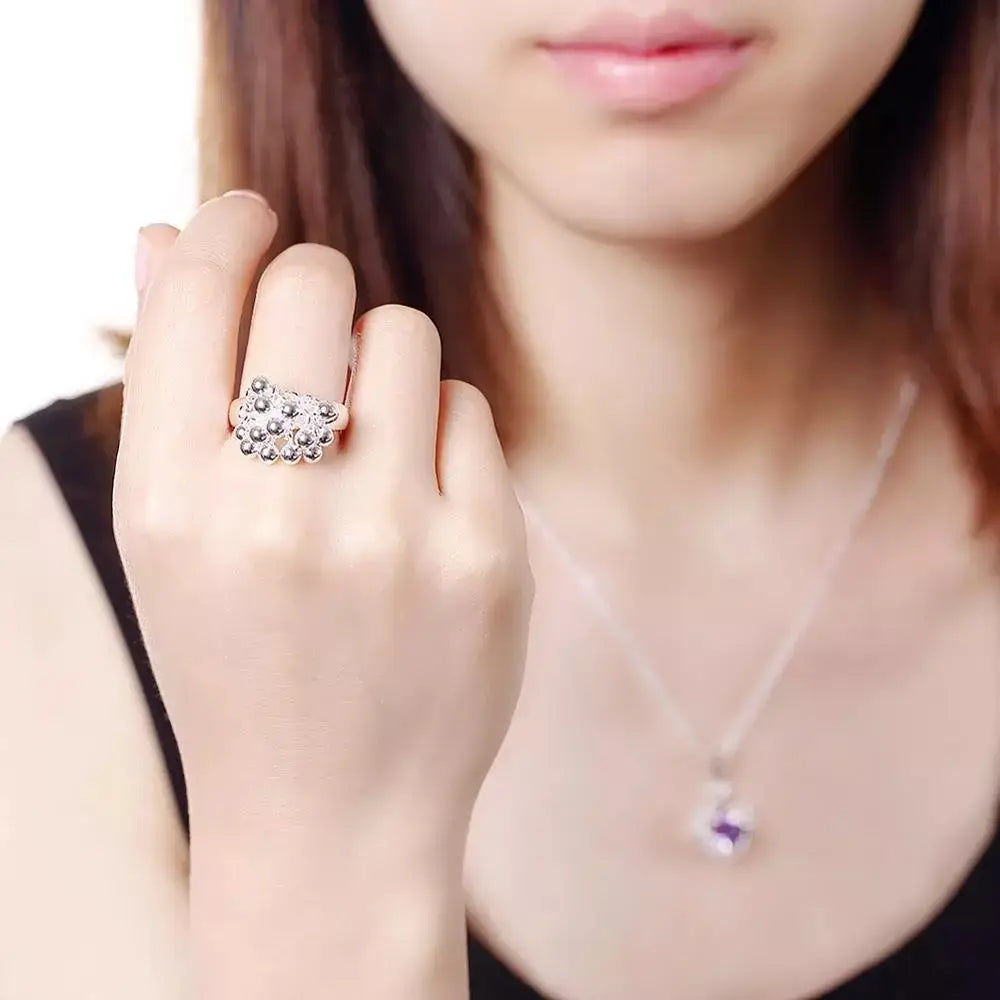 A silver-toned 925 silver grape bead ring featuring a cluster of small round clear stones in an intricate floral design.