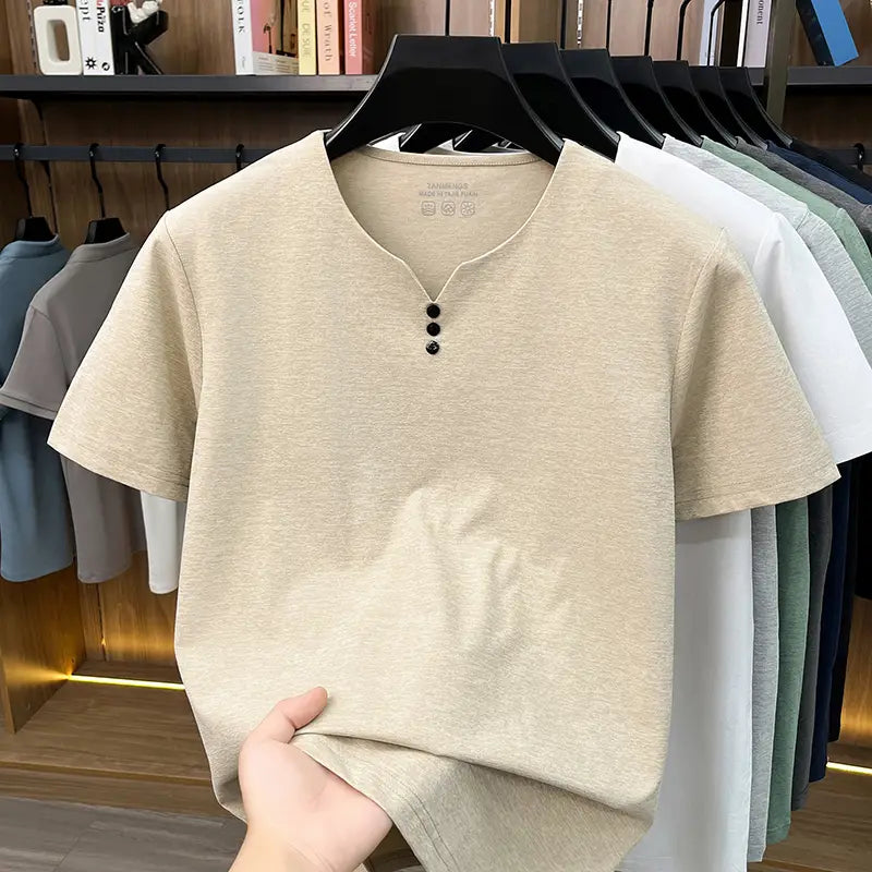 Camisa tipo henley color beige para hombre de manga corta con tres botones negros en el cuello, confeccionada con tejido informal con textura.