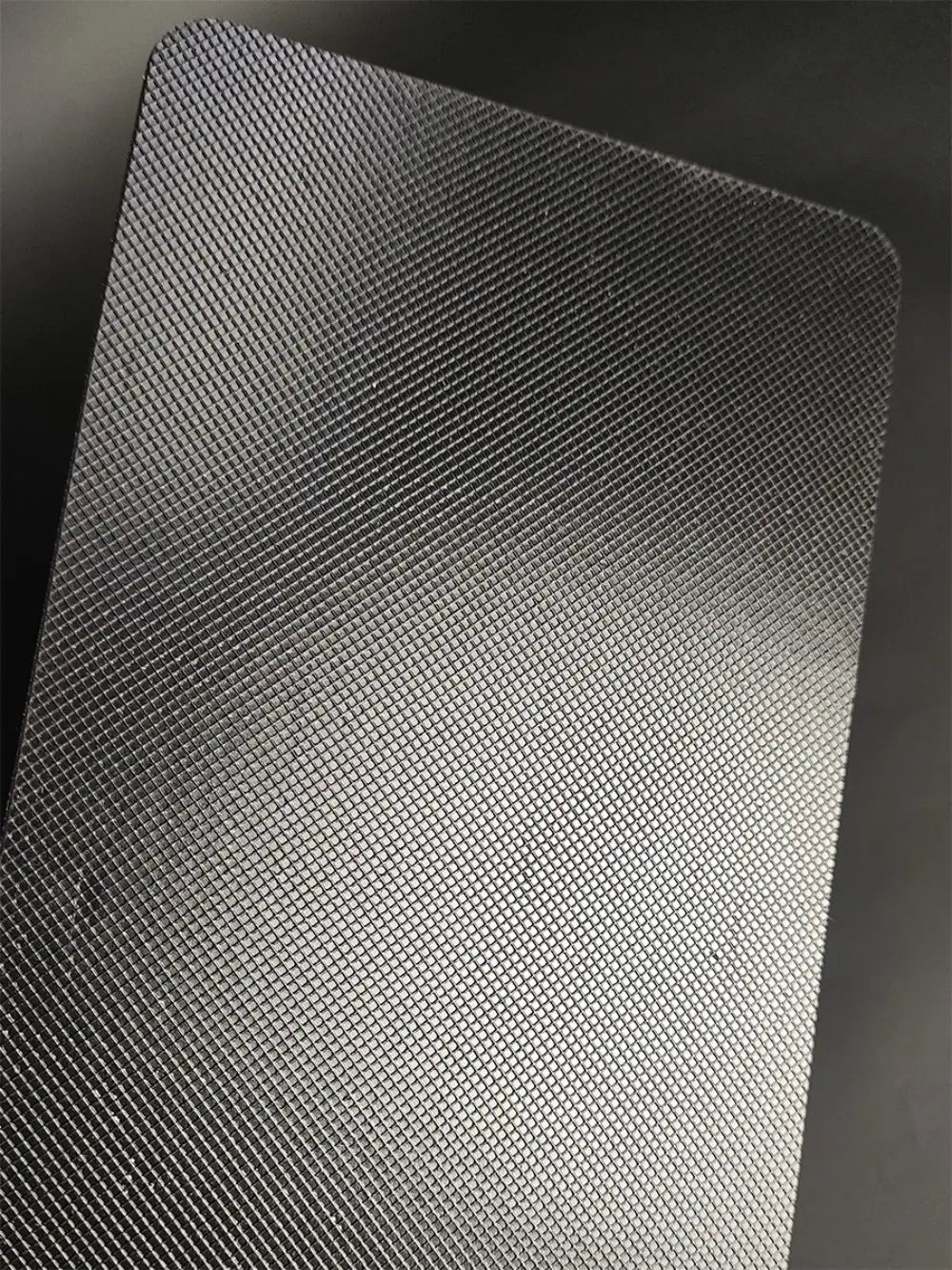 black textured metal plate with fine grid pattern on the back side of djmax mechanical gaming keyboard featuring left joystick support for precise joystick moves and reliable data cable connection
