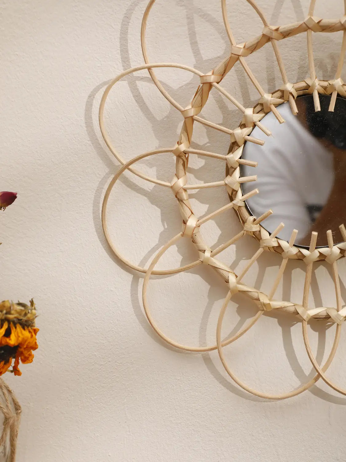Ein beiger, gewebter Rattan-Sonnenstrahl-Wandspiegel mit einem dekorativen Design, ideal zur Aufwertung der ästhetischen Gestaltung des Raums