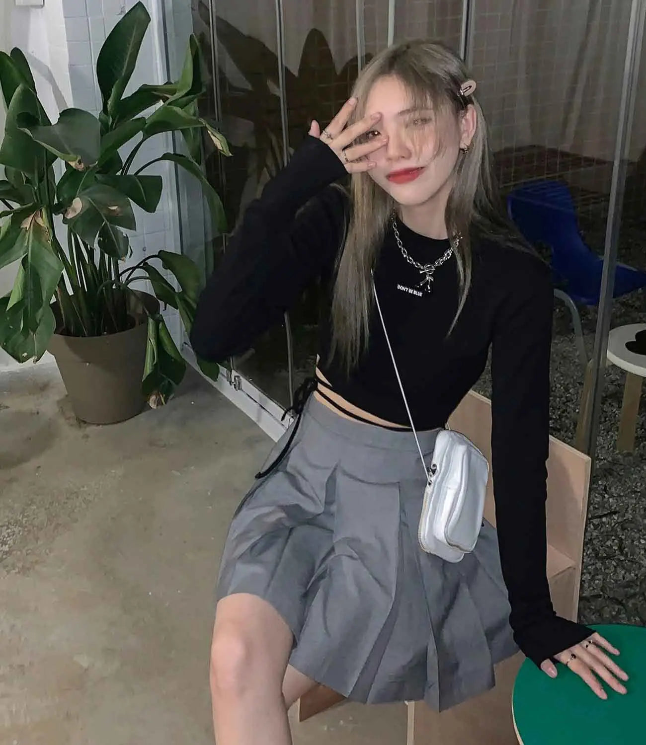 Weiße Umhängetasche mit Kettenriemen und wattierter Struktur, kombiniert mit Damen-Langarm-Crisscross-Crop-Top