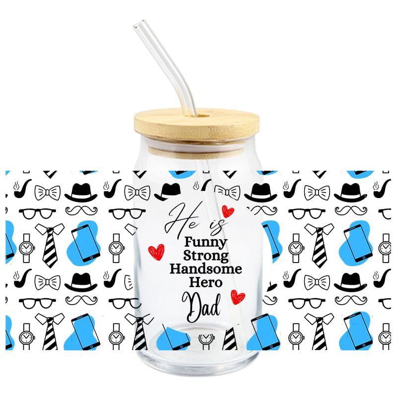 Gobelet transparent en verre avec couvercle en bambou et paille, comportant un motif d’accessoires pour hommes en noir et blanc sur des fonds bleus, avec un texte en cursive indiquant « il est drôle, fort, beau, héros papa », conçu comme une décalcomanie d’enveloppe pour tasse UV DTF pour la Fête des Pères.