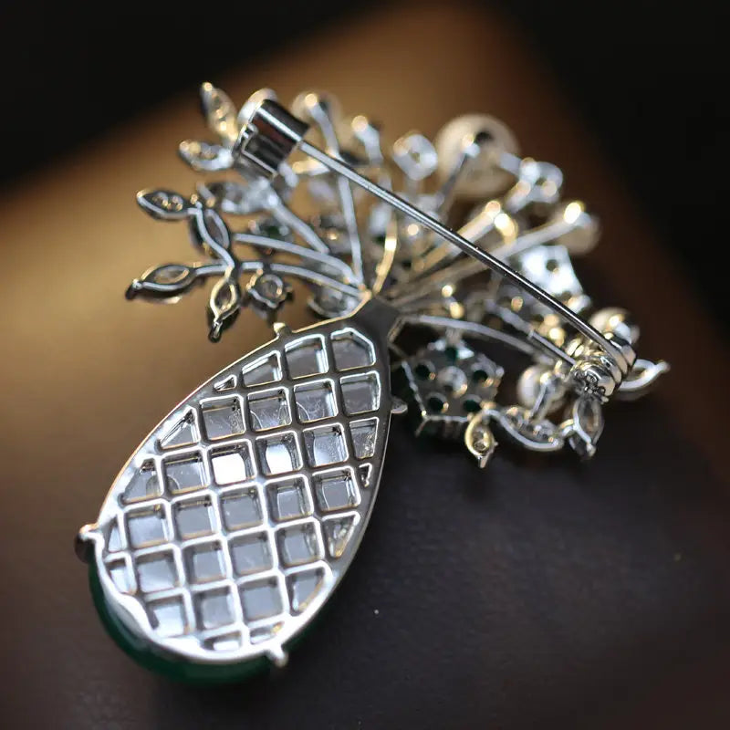 Pin de lujo de diseñador en forma de broche de mariposa de zirconio con un motivo central tipo lágrima en tono de plata, cristales transparentes y una base de jade verde adornada con filigrana intrincada con apariencia de hojas, con gemas incrustadas.