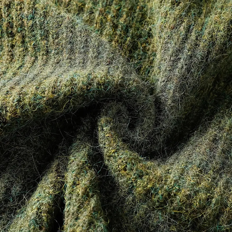 Ein strukturierter Wollschal in Moosgrün und Oliv-Tönen mit flauschigem, leicht ungleichmäßigem Strick, der den Herren-V-Ausschnitt-Strickcardigan ergänzt.