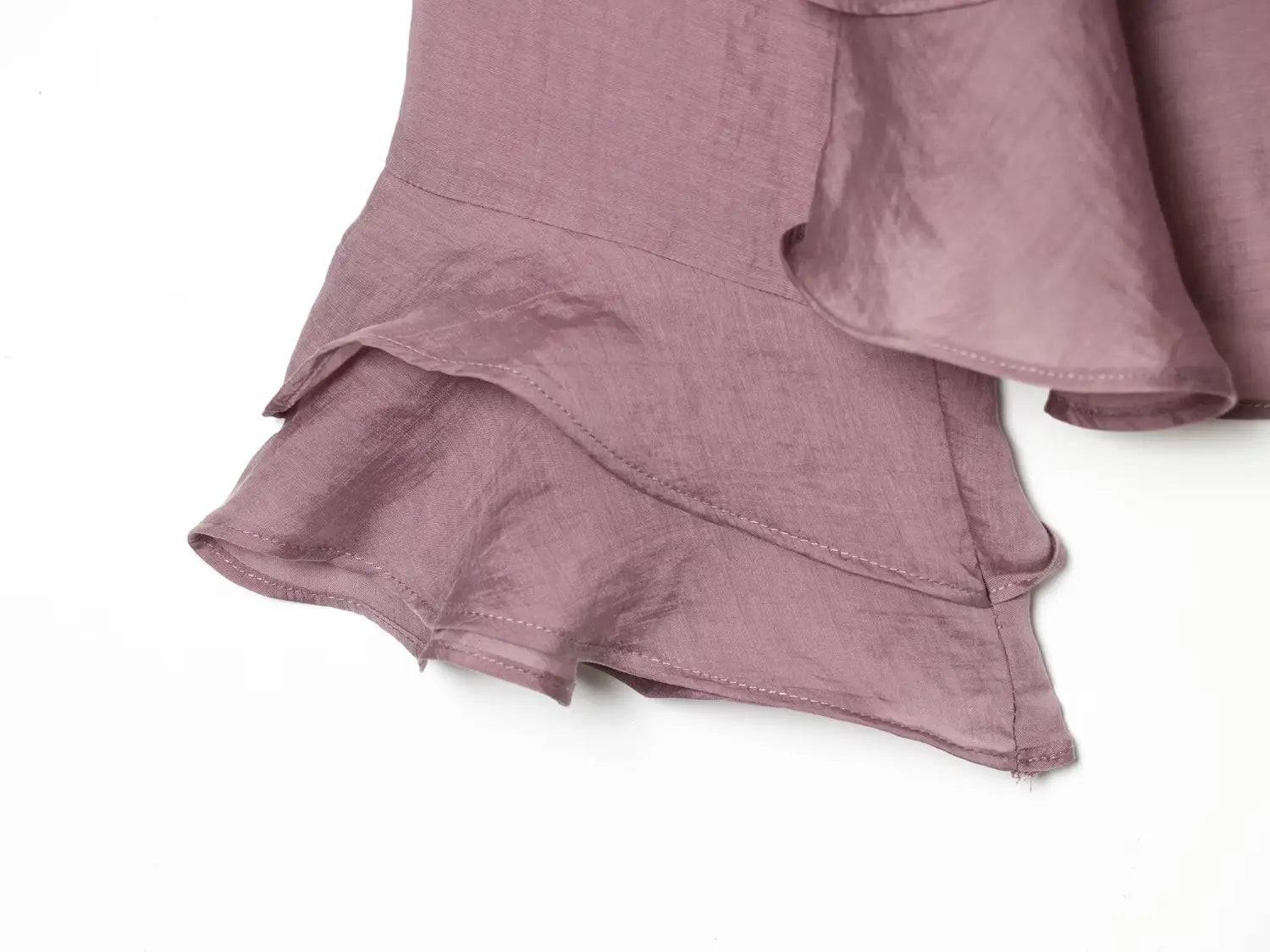 a soft lavender ruffled skirt hem with subtle sheen and delicate stitching paired with a brown chiffon flare sleeve blouse highlighting the sleeve style