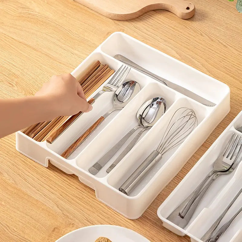 Bac d’organisation réglable pour ustensiles de cuisine en plastique blanc, pour tiroir, avec des compartiments prévus pour les fourchettes, les cuillères, les baguettes et un fouet.