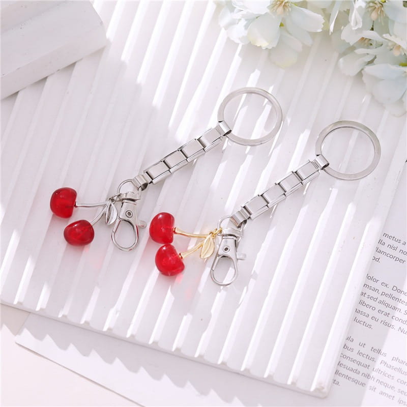 Llavero modular con dije de eslabones italianos con acabado plateado, con dos dijes de cereza roja brillantes con vástagos y hojas en tono dorado para uso personalizado en bricolaje.