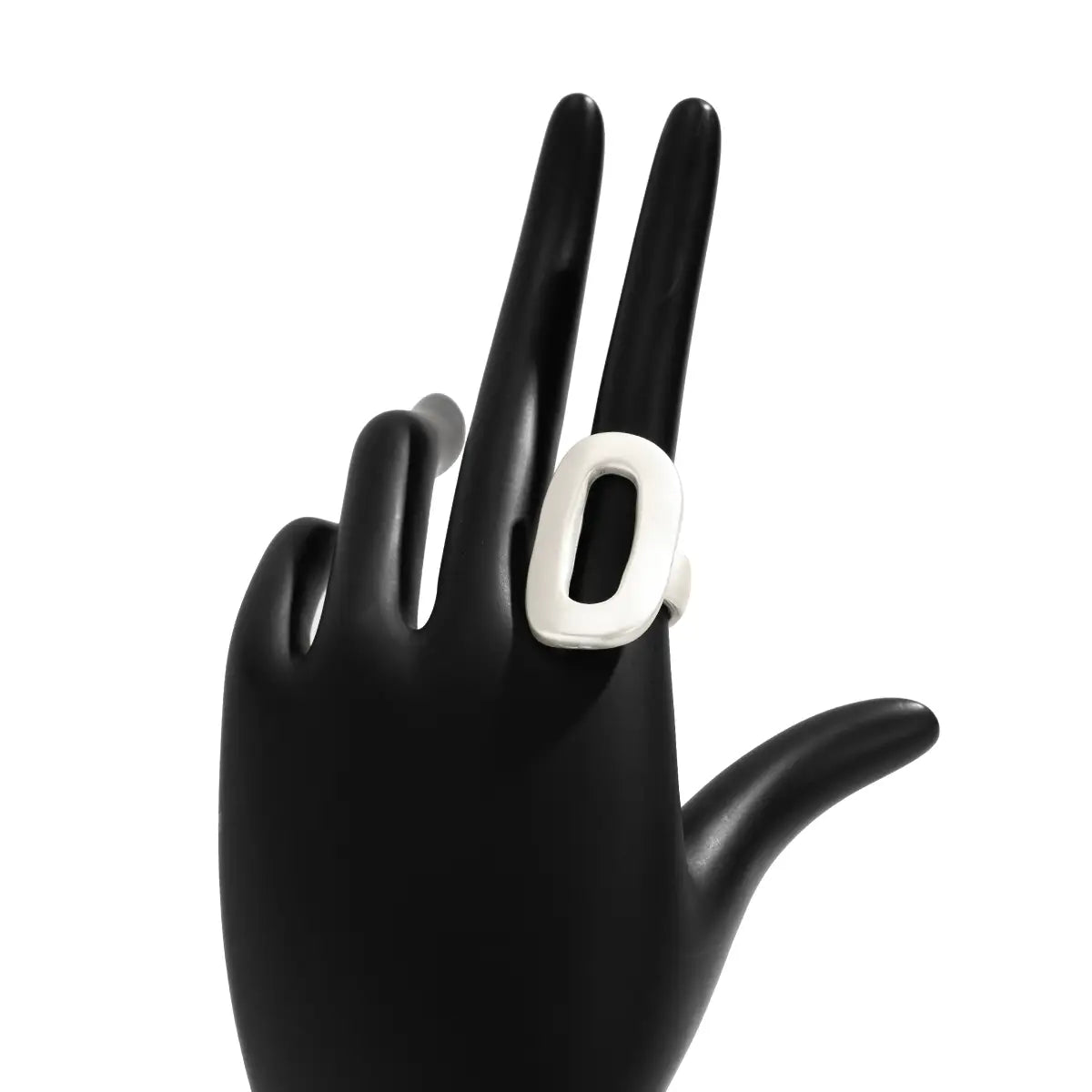 A sleek white geometric oval open ring with a modern minimalist design displayed on the index finger of a black mannequin hand.