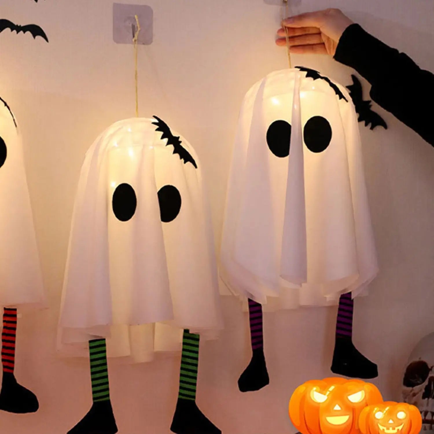 weiße durchscheinende Gespenst-Laternen-Dekorationsanhänger mit schwarzen runden Augen, Fledermaus-Ausschnitten am Kopf und gestreiften Bein-Akzenten mit Märchenlichtern für die Halloween-Party-Dekoration