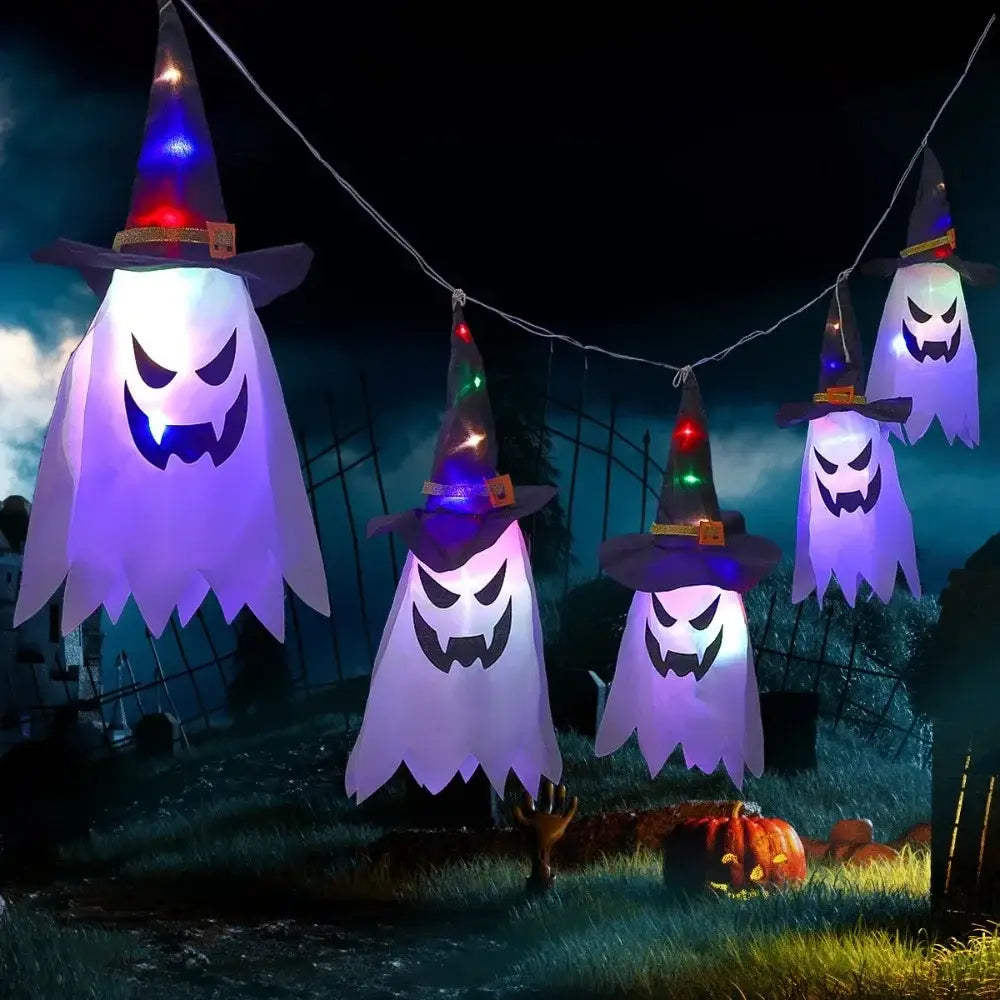 Décoration d’Halloween suspendue en forme de fantôme à DEL, comprenant des fantômes gonflables avec des lumières pourpres et blanches, portant des chapeaux de sorcière pointus avec des boucles orange.