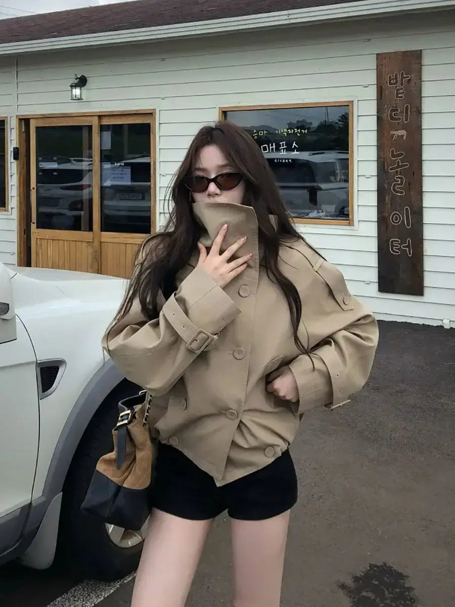 Beige Korean style trench coat utility jacket with belted cuffs and double-breasted front.