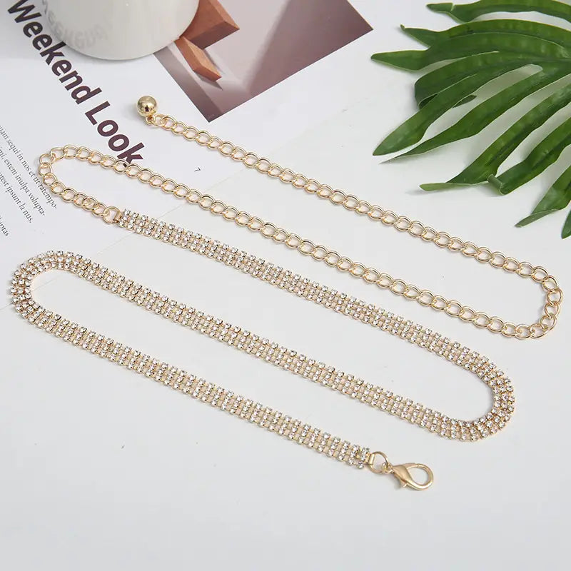 Gold-toned rhinestone chain belt for women featuring a sparkling multi-row design and an adjustable metal lobster clasp waist accessory.