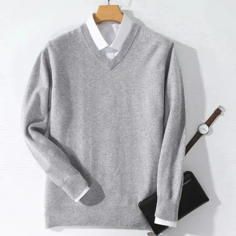Gray cashmere men v neck pullover sweater with ribbed cuffs and hem worn over a white collared shirt.