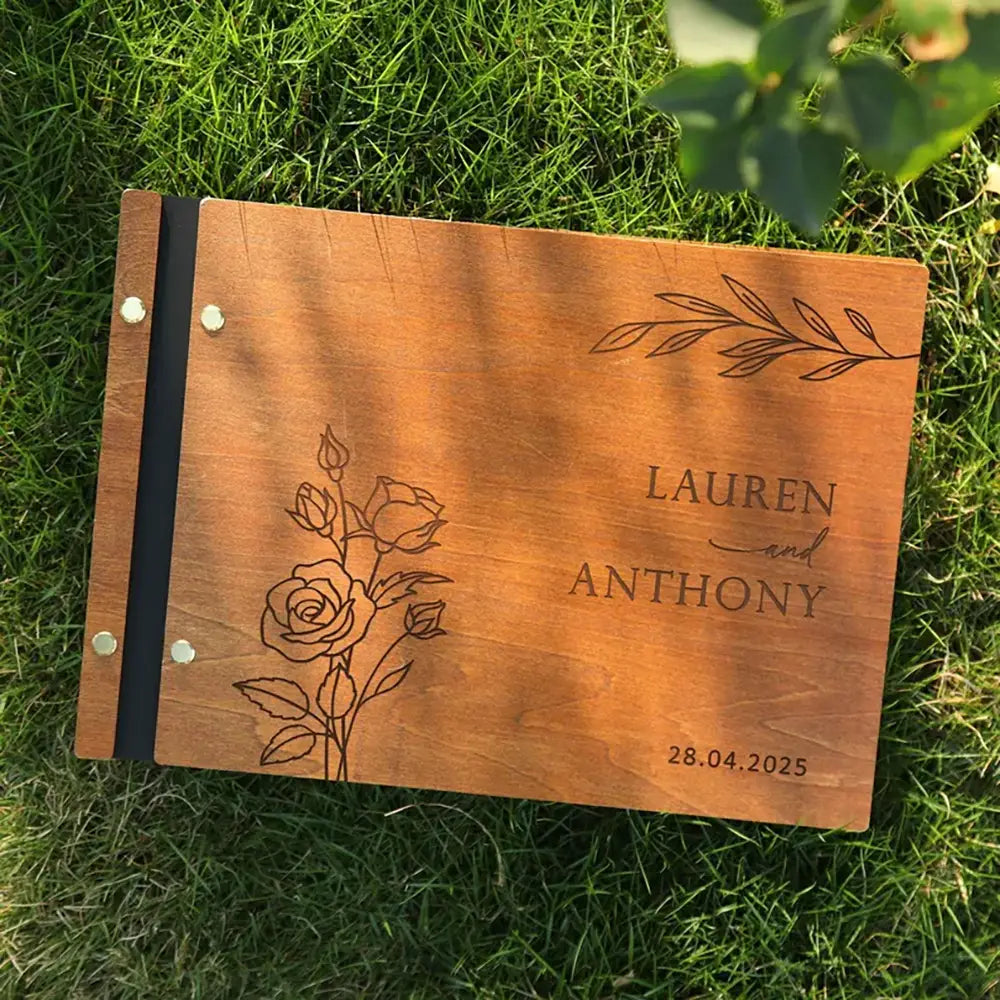 表紙にローズと葉の彫刻デザイン、名の「Lauren」「Anthony」、日付「28.04.2025」をあしらった、温かみのある木目調のパーソナライズ結婚式ゲストブック。