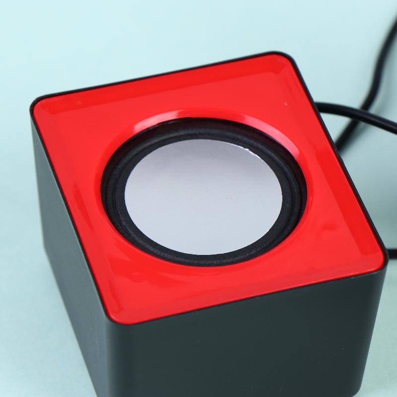 Mini haut-parleurs de bureau USB pour audio stéréo sur ordinateur, avec un design carré rouge et noir et un haut-parleur circulaire, pour une qualité sonore améliorée.