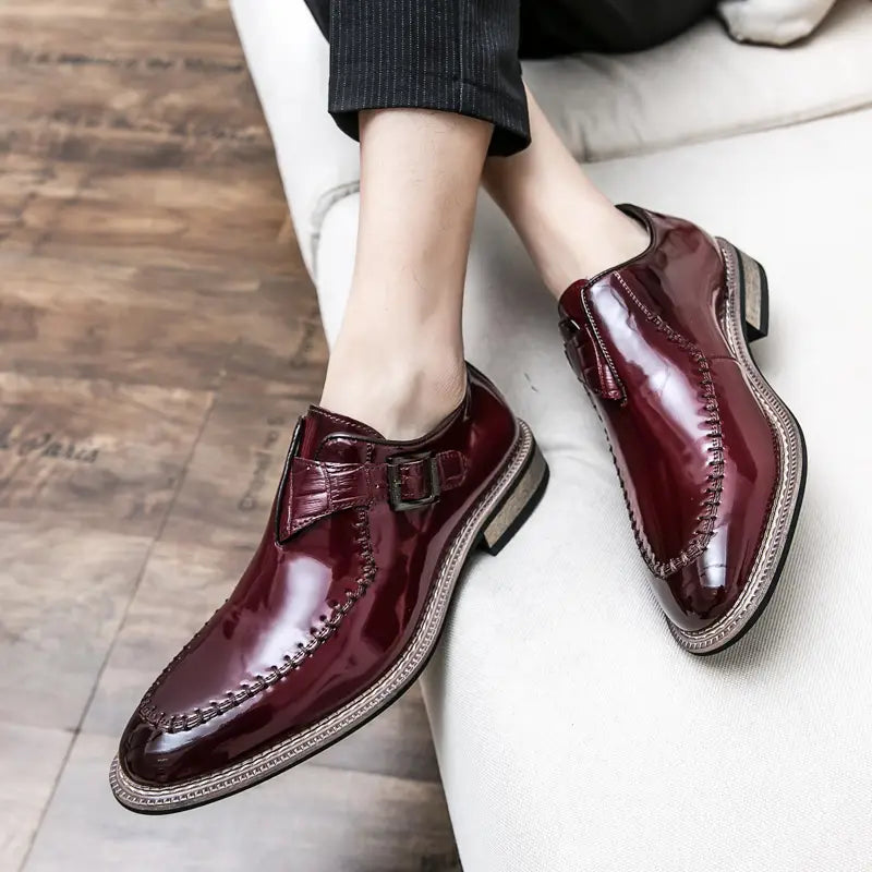 Herren glänzende Lackleder-Kleiderschuhe in poliertem Burgunder mit glänzender Oberfläche und detaillierten Nähten am Mönchriemen-Design.