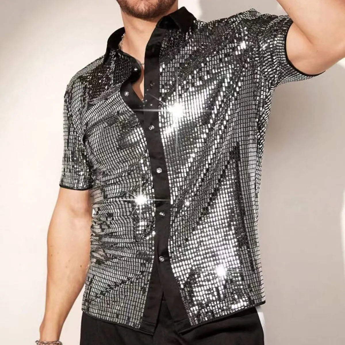 Chemise de scène à manches courtes en sequins pour hommes, avec un tissu à sequins argenté brillant, un col noir et une ouverture boutonnée sur le devant.