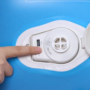 子ども用の旅行用エアマットレスの自動インフレータブル・カーベッドの青色のインフレータブル表面上に、USB-Aコネクタを備えた白い円形のAC/DC充電ポート。