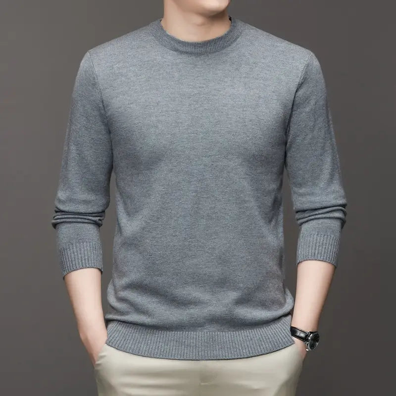 Ein klassischer Herren-Strickpullover mit Rundhalsausschnitt aus heather-grau mit gerippten Bündchen und Saum aus Strickstoff.