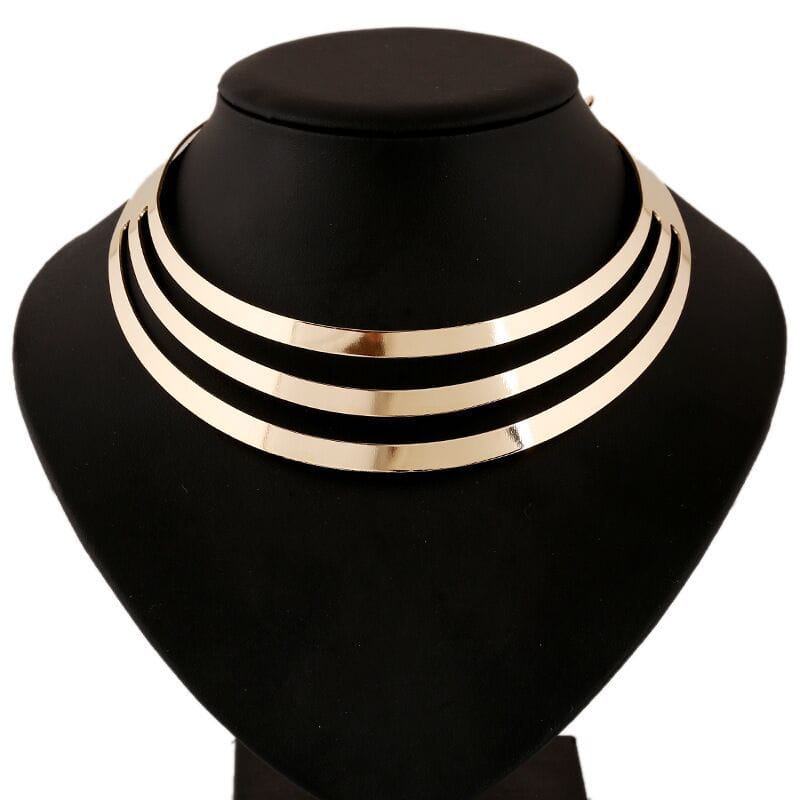 Un collar tipo gargantilla multicapa con tono dorado, de líneas elegantes, con un diseño moderno minimalista de cadena punk.