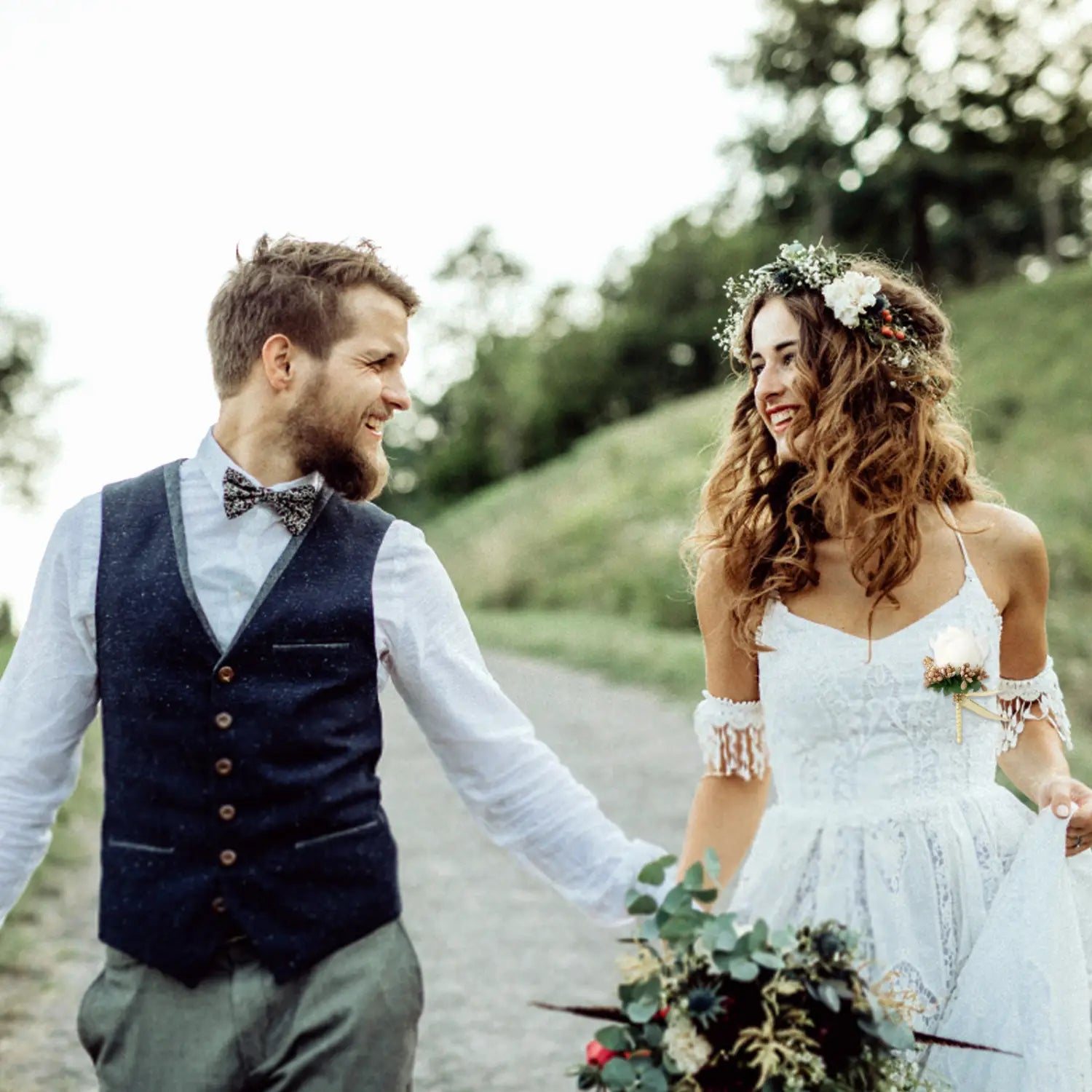 White lace wedding dress with off-the-shoulder sleeves and floral embellishments paired with a blue wedding boutonniere artificial silk rose corsage.