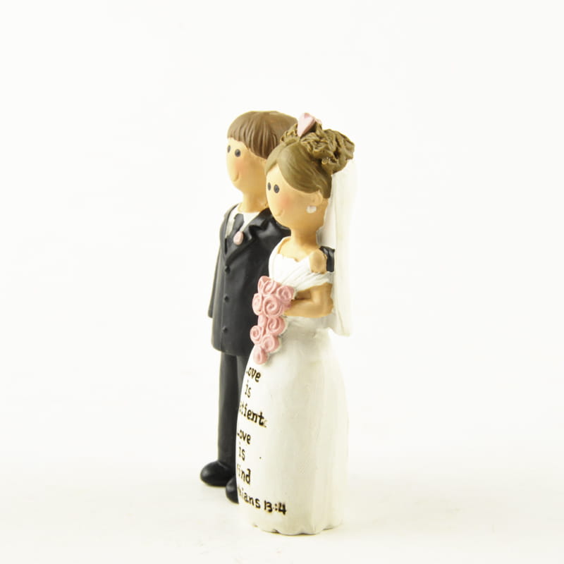 décoration de table en résine blanche et noire pour figurine de jeune fille de première communion, représentant une mariée tenant des roses roses et un marié en tenue de cérémonie, avec l’inscription « romains 12 10 » gravée sur la robe de la mariée