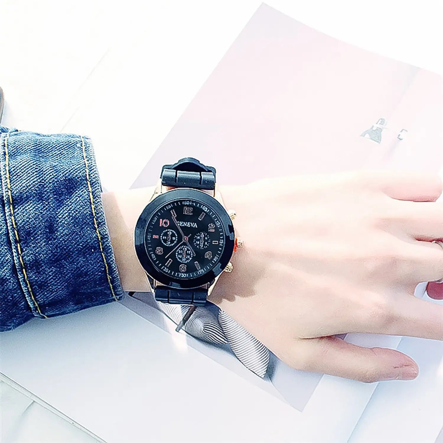 Black and gold women silicone quartz fashion chronograph watch with a black rubber strap worn on a wrist.