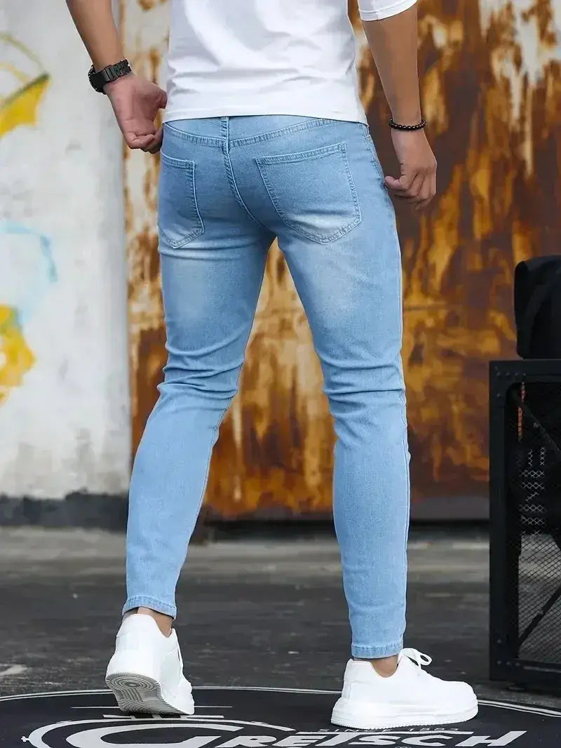 Jeans en denim bleu foncé coupe slim pour homme présentant un design slim en denim bleu clair, avec un style classique à cinq poches.