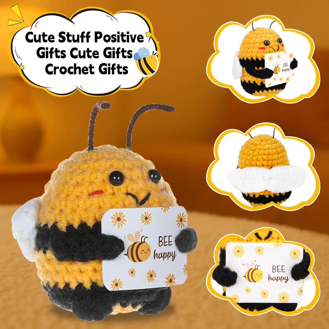 un peluche de abeja tejido a ganchillo color amarillo y negro que sostiene una tarjeta de abeja feliz, presentado como llavero y accesorio para bolso de abeja positiva