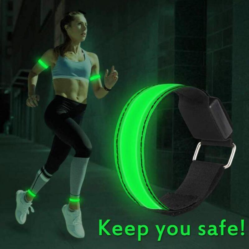 Brazalete de seguridad LED recargable por USB para correr, con banda reflectante luminosa verde, correa marrón oscuro y hebilla plateada.
