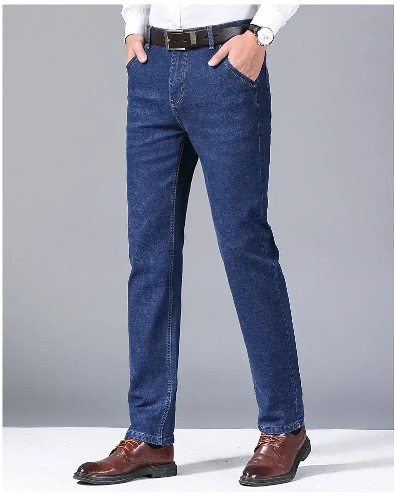Jeans en denim extensible à coupe slim pour hommes en bleu foncé, avec une coupe droite et des surpiqûres classiques.