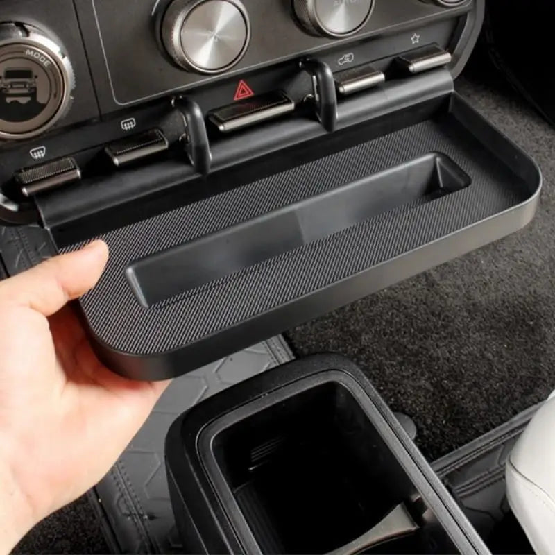 La bandeja organizadora para consola central Icar V23 es un accesorio para automóvil con textura de fibra de carbono en color negro, que incluye un compartimento de almacenamiento integrado para una organización eficiente.