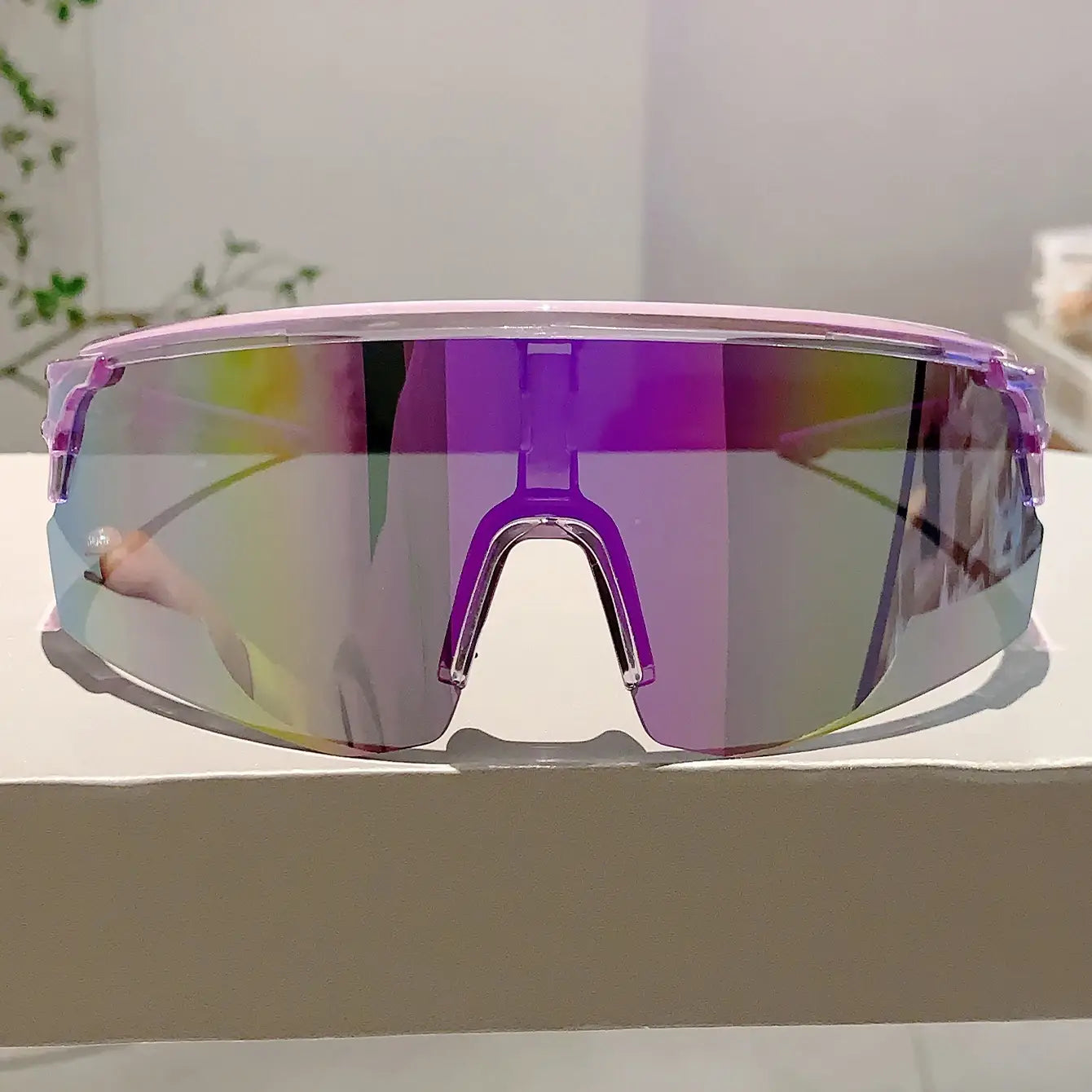 Lunettes de soleil de sport surdimensionnées pourvues d’un effet miroir violet, avec une monture transparente élégante, conçues comme lunettes de cyclisme.