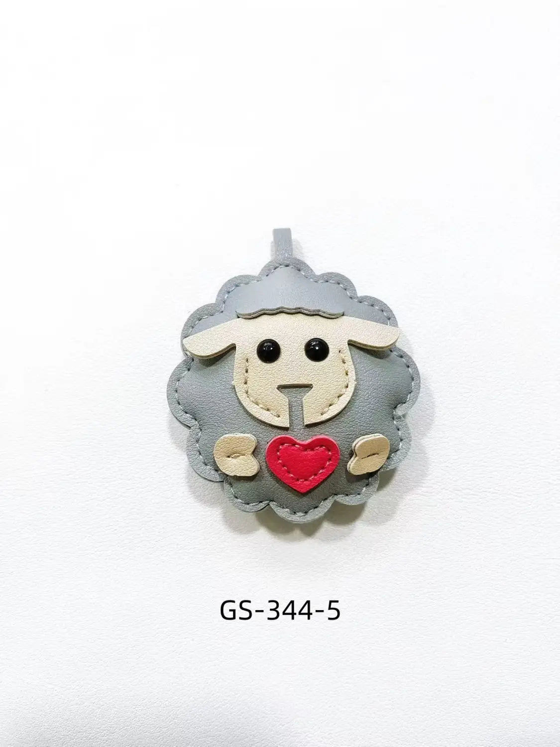 Gray leather sheep-shaped keychain with cream-colored face details and a red heart stitched on its chest as a cute animal bag charm.