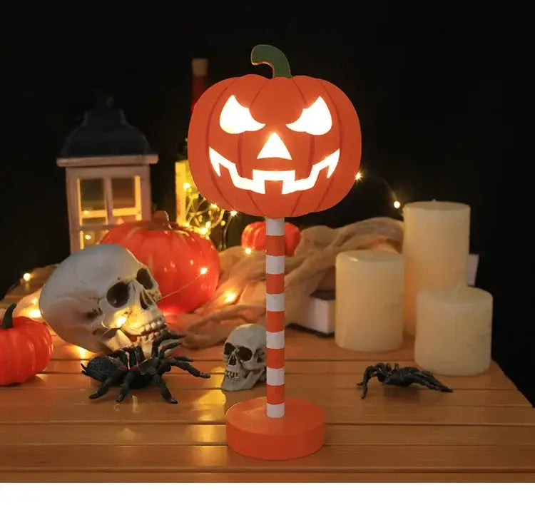 Oranger Kürbis-förmiger Halloween-LED-Nachtlicht mit leuchtend geschnitztem Gesicht, montiert auf einem roten und weißen, gestreiften Stab für eine wassergeschützte Dekoration.