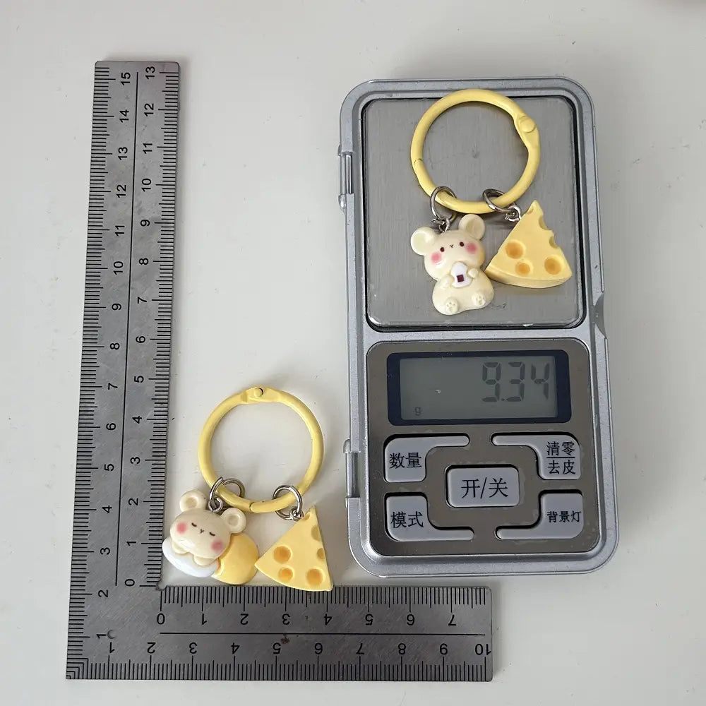 Yellow plastic keychain featuring a cute white mouse and cheese slice charm as a kawaii bag charm named Cheese Mouse Cartoon Keychain.