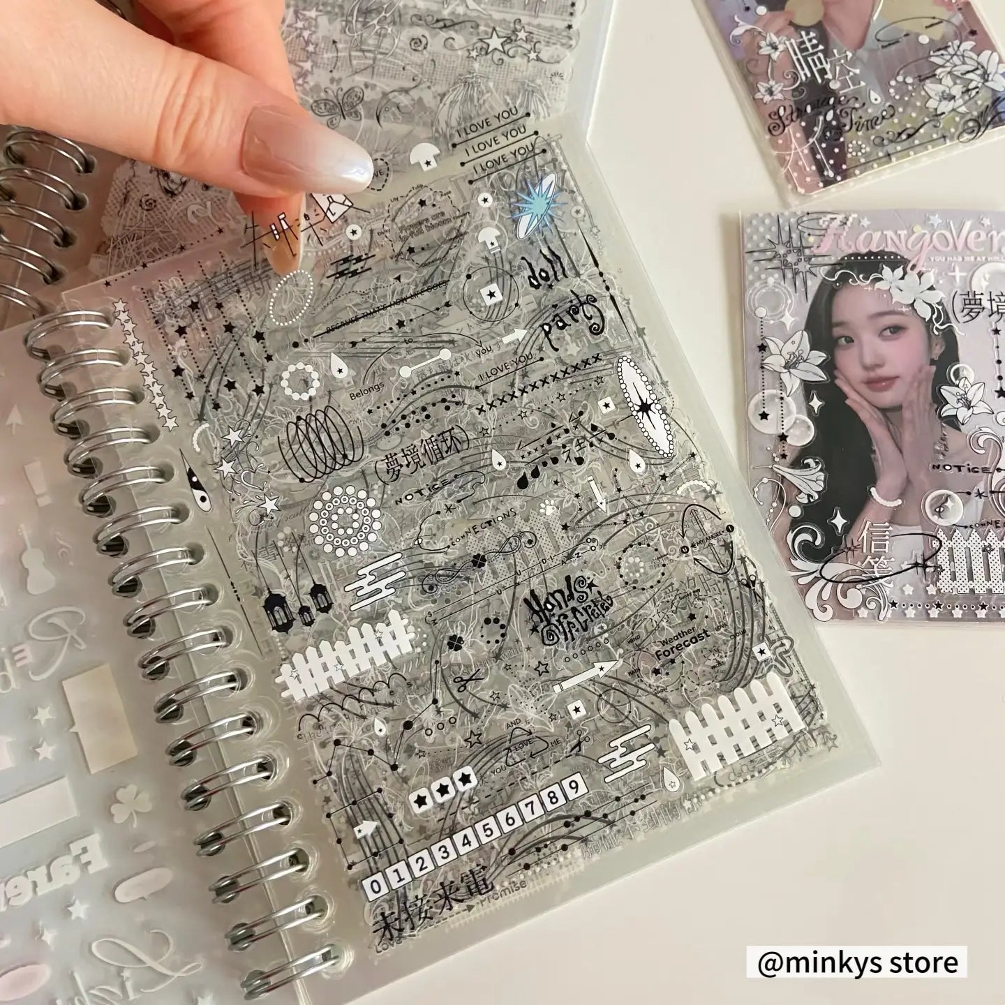 klare transparente Stickerbogen mit filigranen schwarzen Linienkunst-Designs, einschließlich Sätzen wie „I love you“, Totenköpfen, Sternen, Zahlen und dekorativen Mustern aus dem „kawaii kpop sticker book spiral journal stationery“-Sortiment