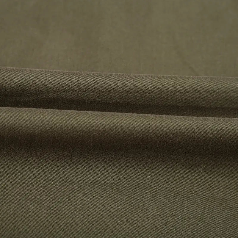 Olive green woven fabric with a subtle textured weave on a men cotton casual long sleeve military cargo shirt.