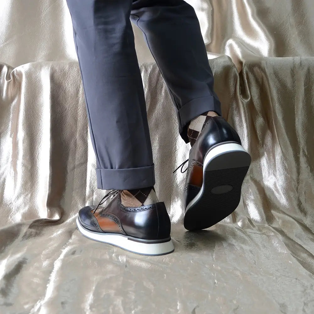 Escarpins brogue wingtip en cuir noir et marron avec une semelle en caoutchouc blanche.