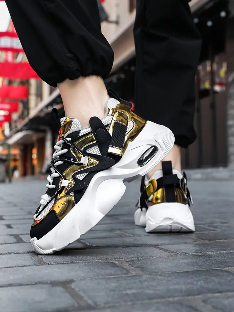 Men chunky air cushion casual sneakers featuring black and gold leather with white mesh accents and a thick cushioned sole.