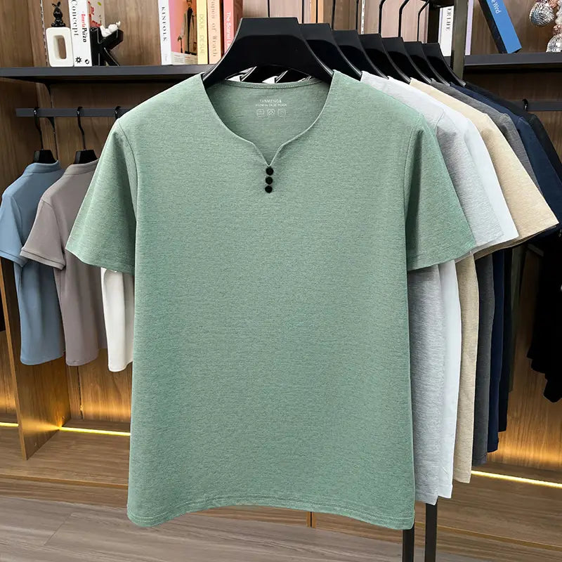 Una camisa tipo henley de manga corta color verde menta suave, con una textura jaspeada sutil y tres botones negros en el cuello, diseñada como camiseta informal con textura para hombre.