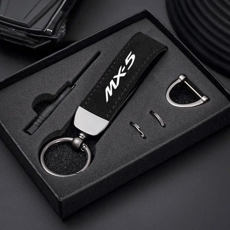 Black leather Mazda MX-5 keychain with silver MX-5 logo and metallic hardware for car key ring holder.