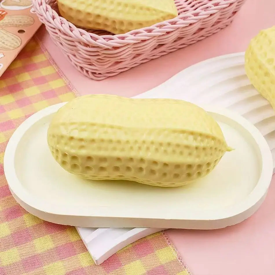 a pale yellow peanut squishy filled stress toy with textured dotted surface designed for squeezing and stress relief